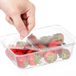 a close up shot of a hand peeling back the lidding film off a clear container with strawberries in it